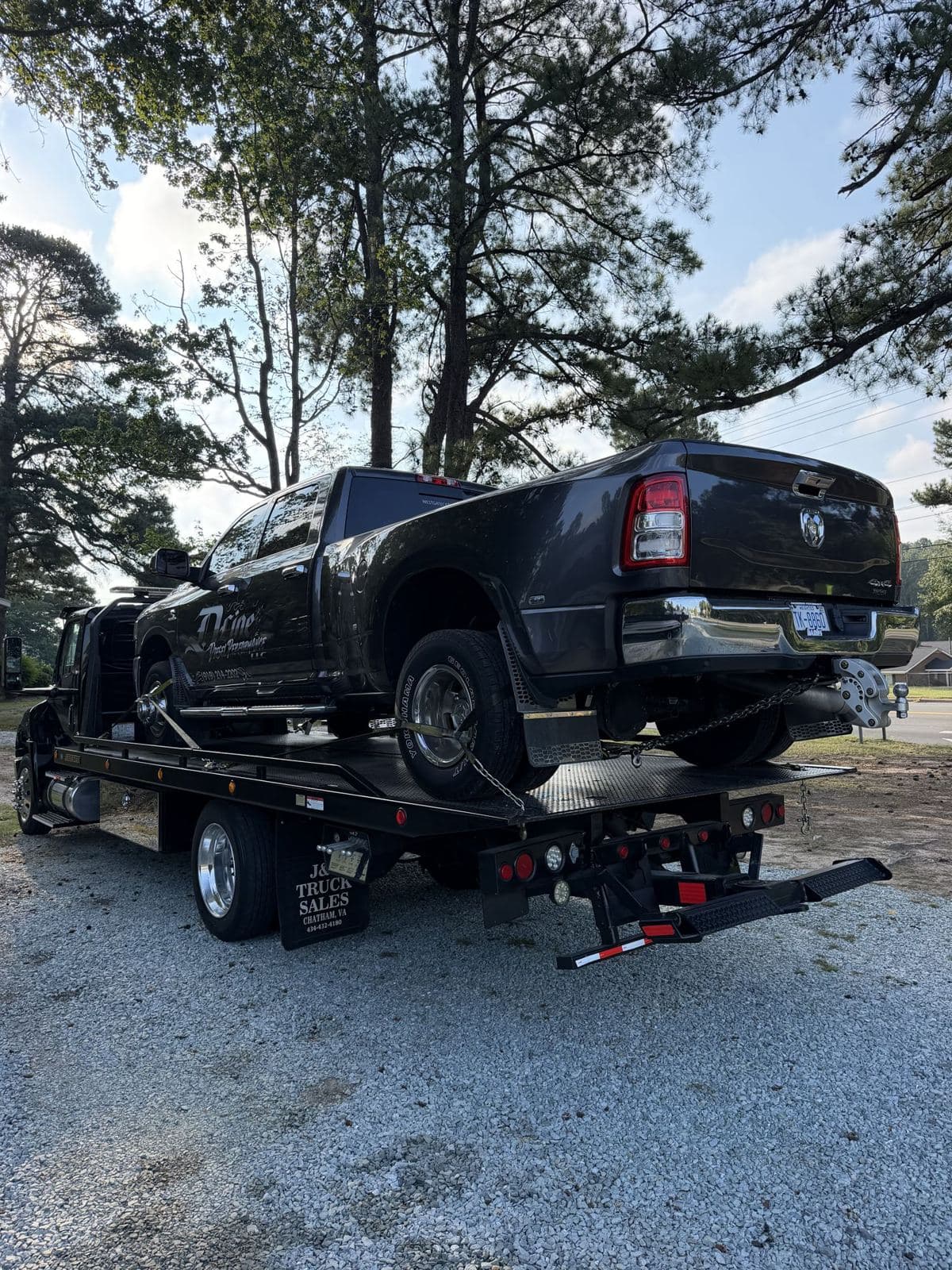 Raleigh towing: dually pickup chained down on a 22-ft rollback tow truck